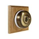 Switch to Wood's Dolly Light Switch Smooth Dome - 1 Gang Square Backplate Antique Brass in Light Oak