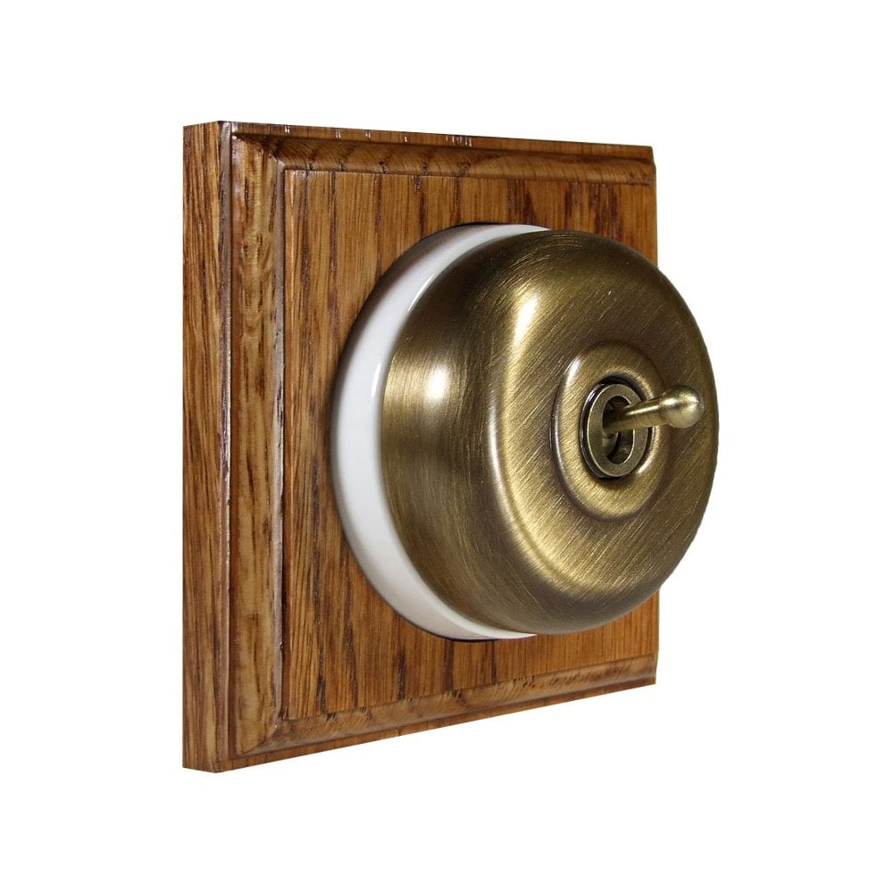 Switch to Wood's Dolly Light Switch Smooth Dome - 1 Gang Square Backplate Antique Brass in Medium Oak 