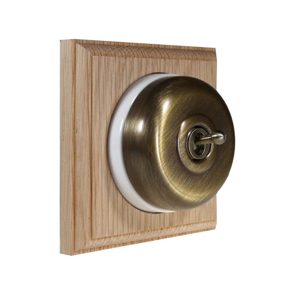 Switch to Wood's Dolly Light Switch Smooth Dome - 1 Gang Square Backplate Antique Brass in Unfinished Oak