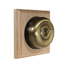 Switch to Wood's Dolly Light Switch Smooth Dome - 1 Gang Square Backplate Antique Brass in Unfinished Oak