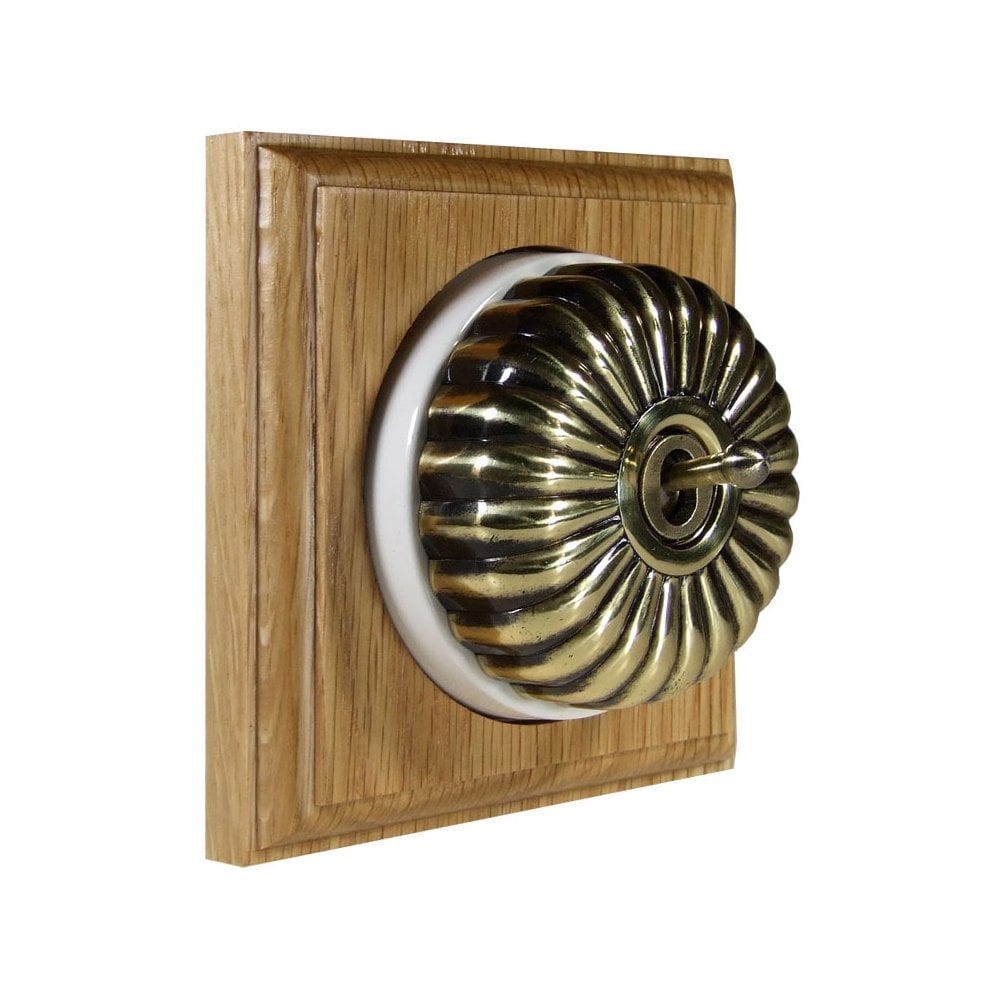 Switch to Wood's Dolly Light Switch Fluted Dome - 1 Gang Square Backplate Antique Brass in Light Oak