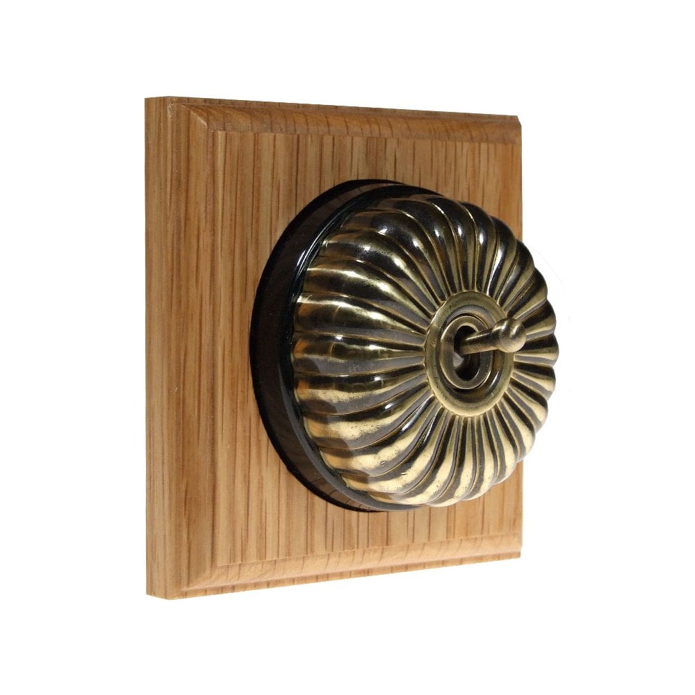 Switch to Wood's Dolly Light Switch Fluted Dome - 1 Gang Square Backplate Antique Brass in Light Oak
