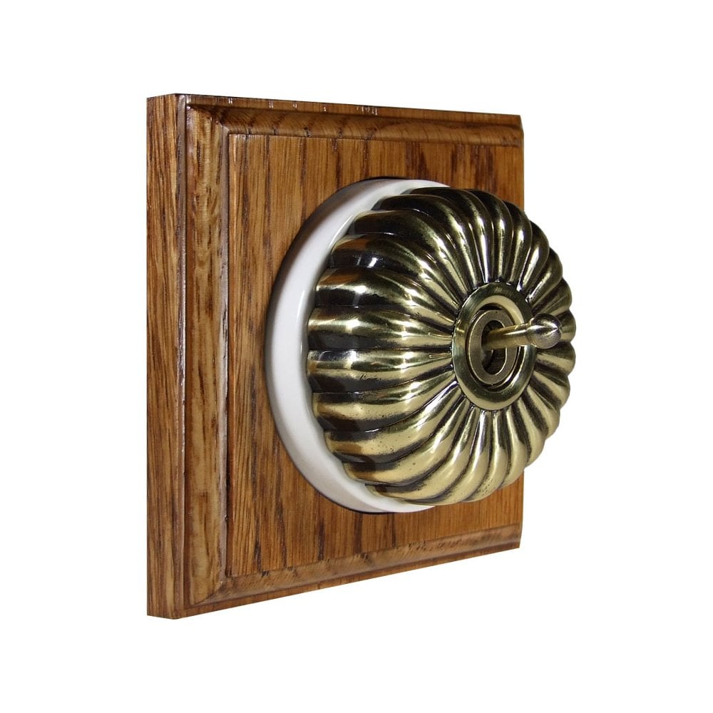 Switch to Wood's Dolly Light Switch Fluted Dome - 1 Gang Square Backplate Antique Brass in Medium Oak 