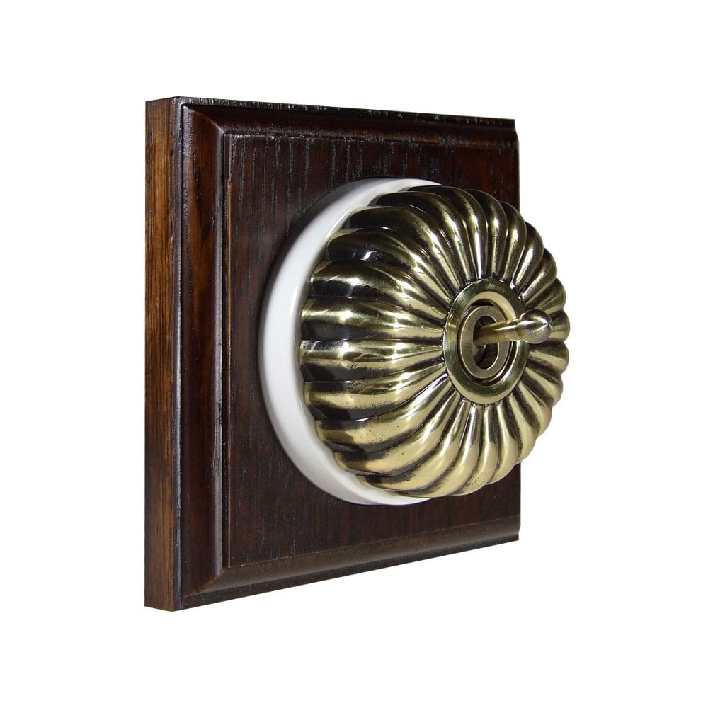 Switch to Wood's Dolly Light Switch Fluted Dome - 1 Gang Square Backplate Antique Brass in Dark Oak