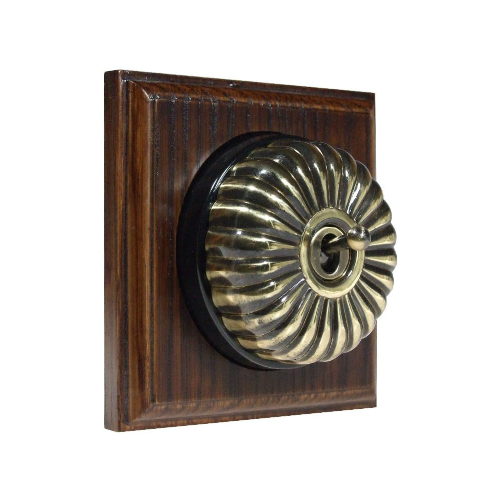 Switch to Wood's Dolly Light Switch Fluted Dome - 1 Gang Square Backplate Antique Brass in Dark Oak