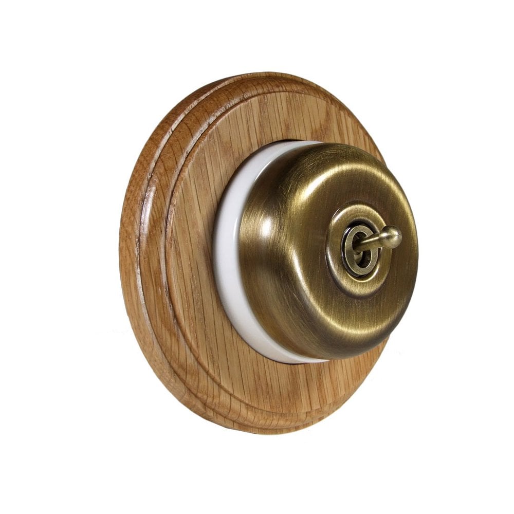 Switch to Wood's Dolly Light Switch Smooth Dome - 1 Gang Round Backplate Antique Brass in Light Oak