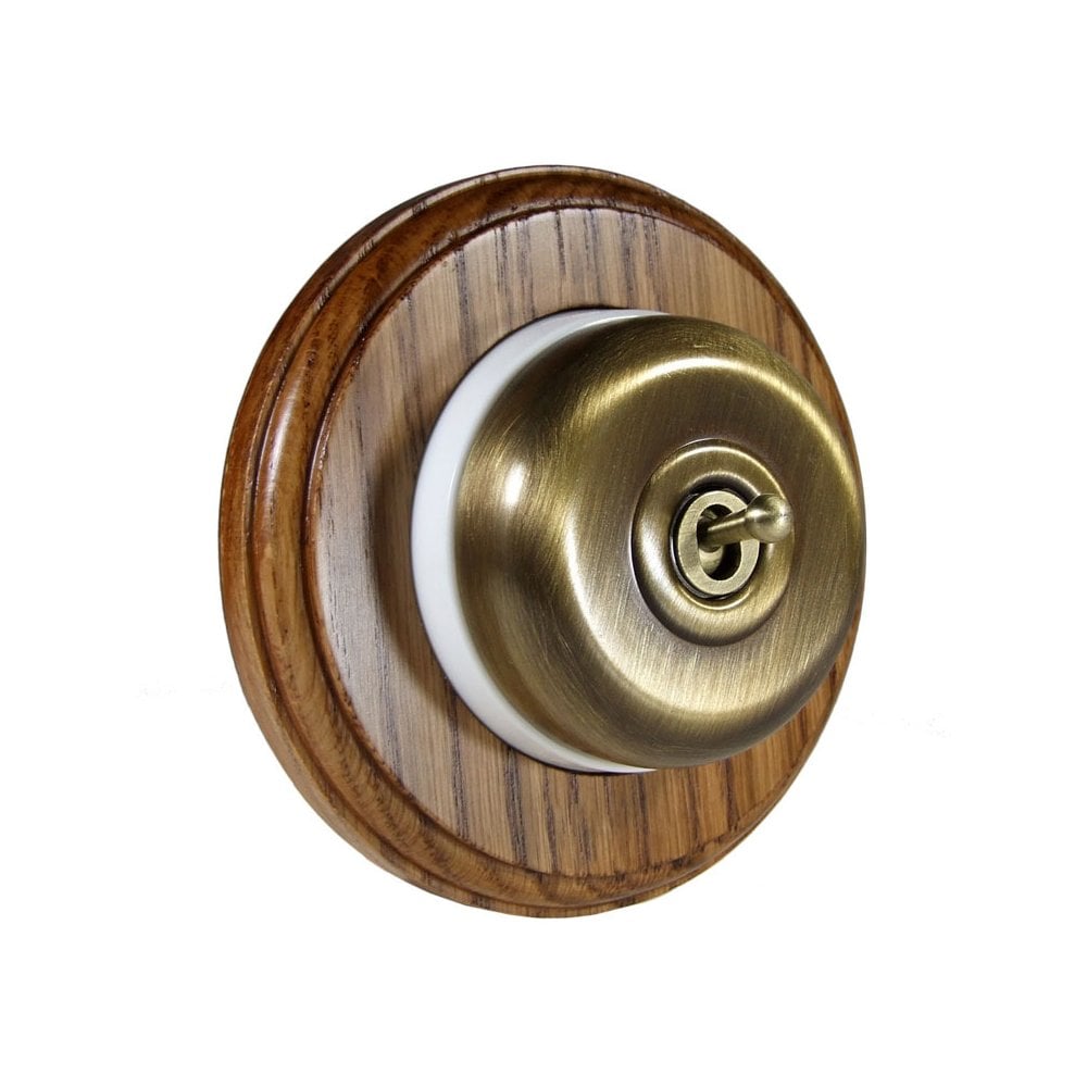Switch to Wood's Dolly Light Switch Smooth Dome - 1 Gang Round Backplate Antique Brass in Medium Oak 
