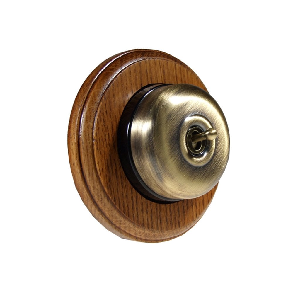 Switch to Wood's Dolly Light Switch Smooth Dome - 1 Gang Round Backplate Antique Brass in Medium Oak 