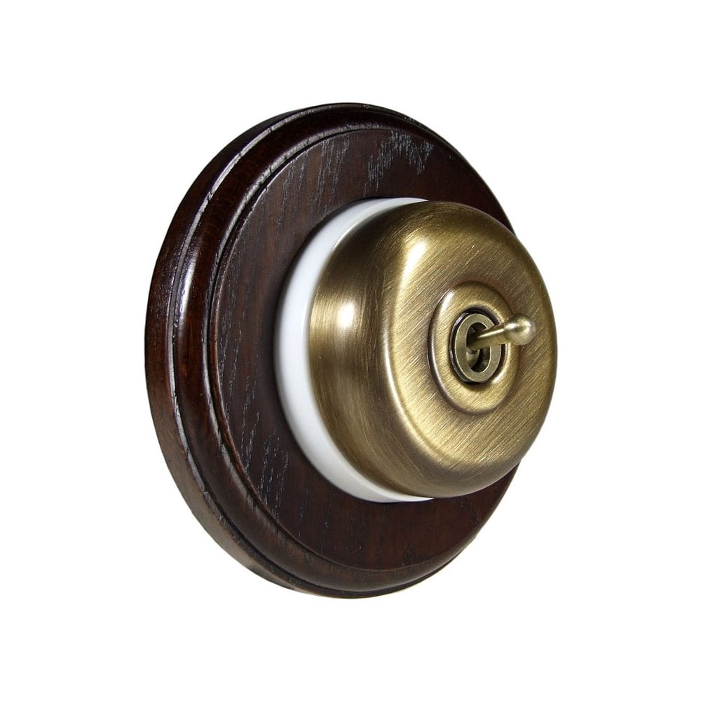 Switch to Wood's Dolly Light Switch Smooth Dome - 1 Gang Round Backplate Antique Brass in Dark Oak