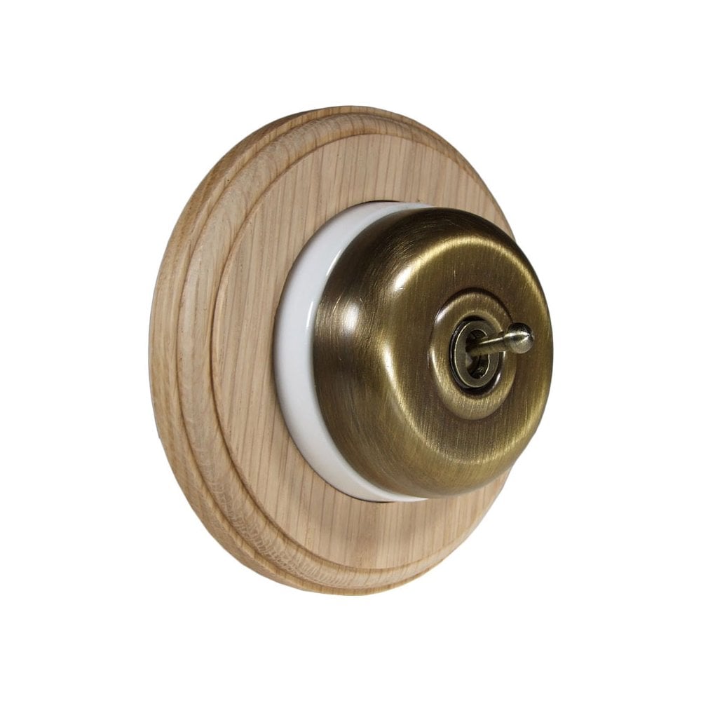 Switch to Wood's Dolly Light Switch Smooth Dome - 1 Gang Round Backplate Antique Brass in Unfinished Oak
