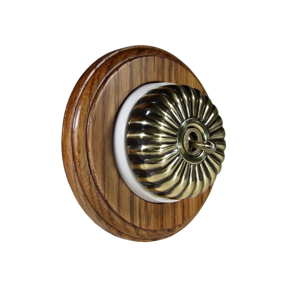 Switch to Wood's Dolly Light Switch Fluted Dome - 1 Gang Round Backplate Antique Brass in Medium Oak 