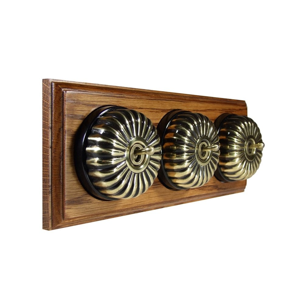 Switch to Wood's Dolly Light Switch Fluted Dome - 3 Gang Horizontal Antique Brass in Medium Oak 