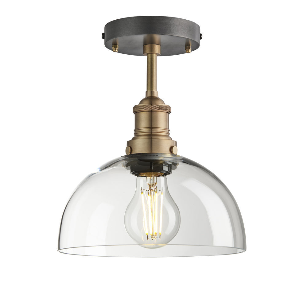 Industrial-style pendant light with a glass dome with a brass holder.