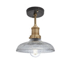 Industrial-style pendant light with a glass dome with a brass holder.
