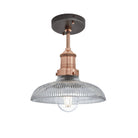 Industrial-style pendant light with a glass dome with a copper holder.